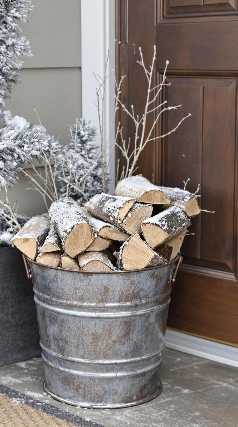 15 Gorgeous Winter Porch Decor Ideas to Spark Your Creativity 32 11. Winter-Themed Galvanized Metal Bucket with Firewood-1