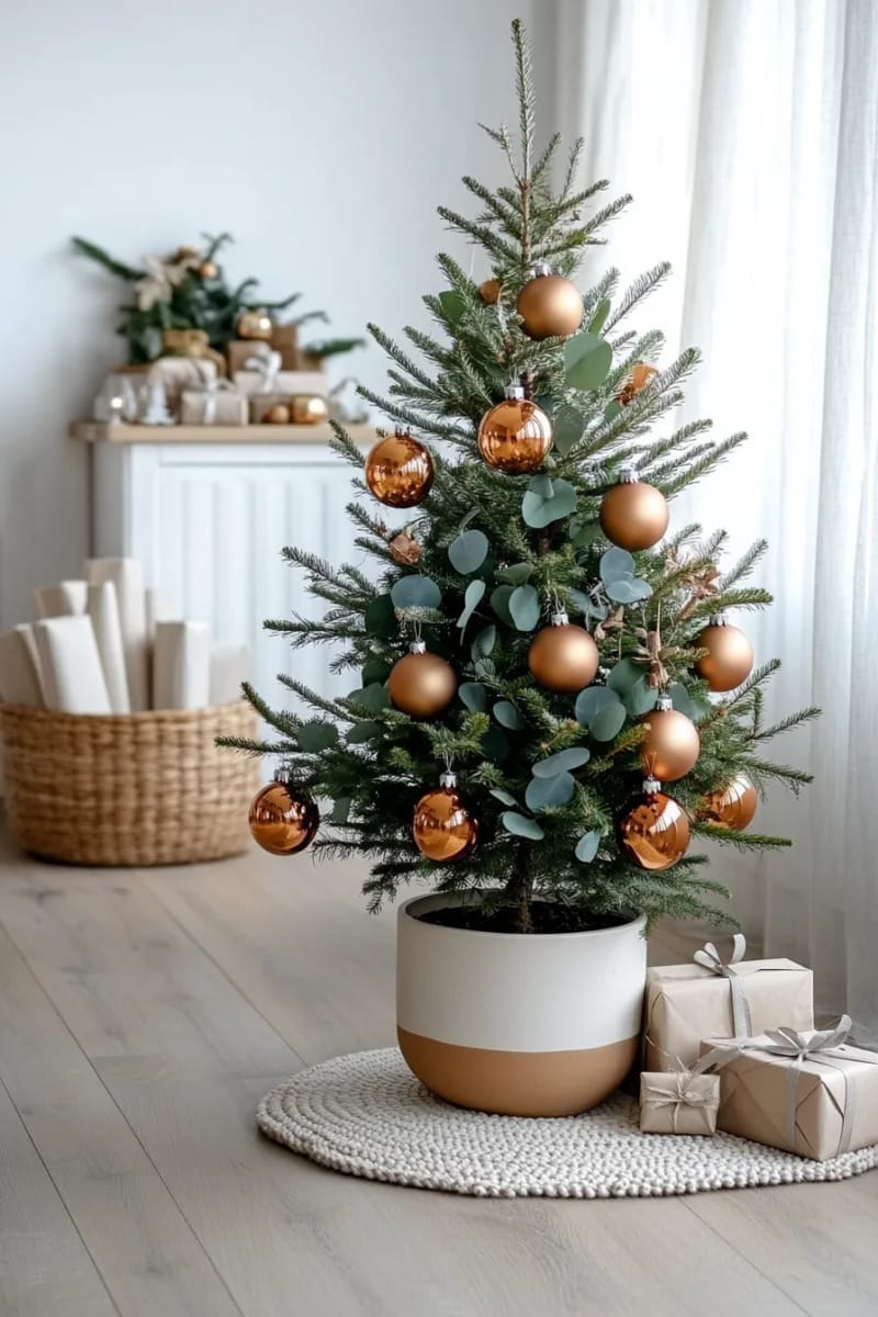 modern minimalist tree with amber glass ornaments and eucalyptus sprigs 1